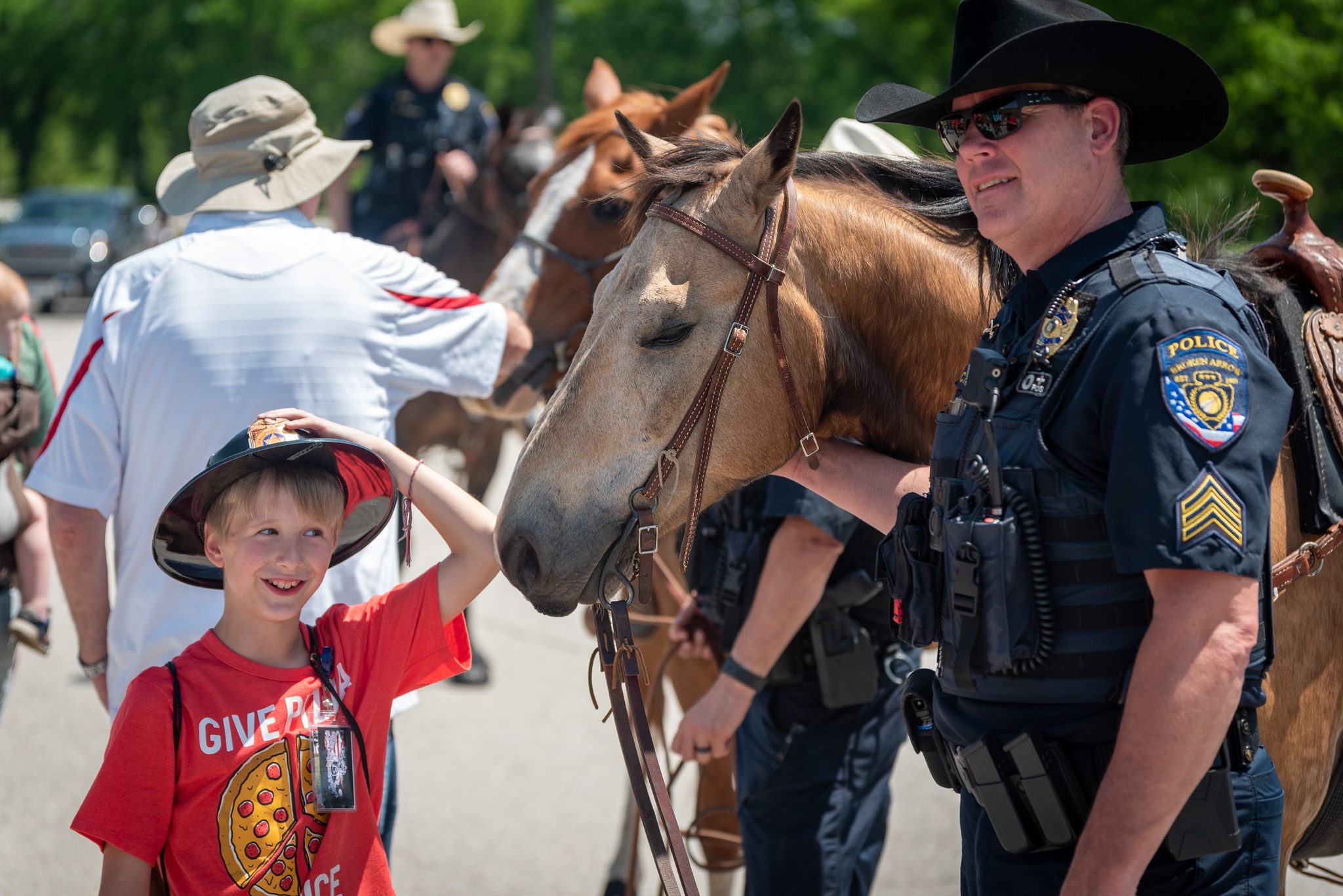Young boy visits with mounted police officer at Camp Bandage in Broken Arrow.