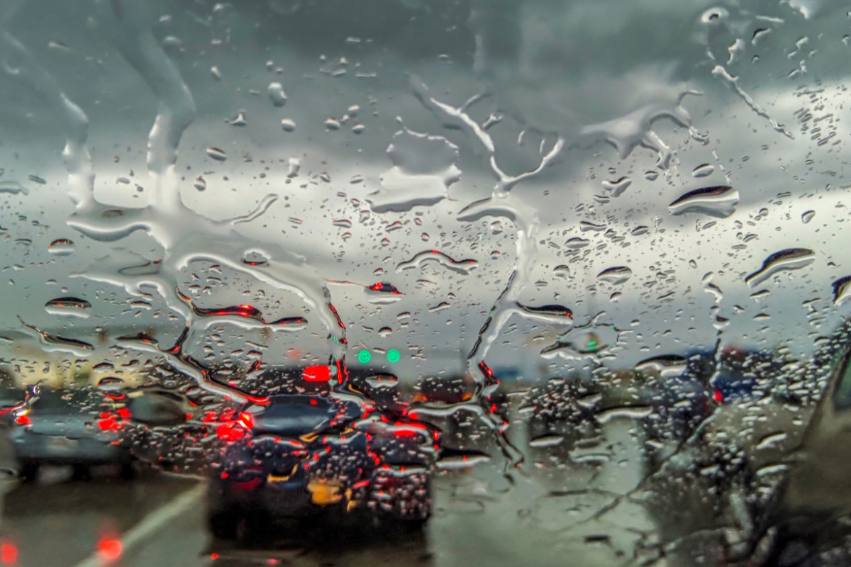 Heavy traffic through the windshield of a car during rain.